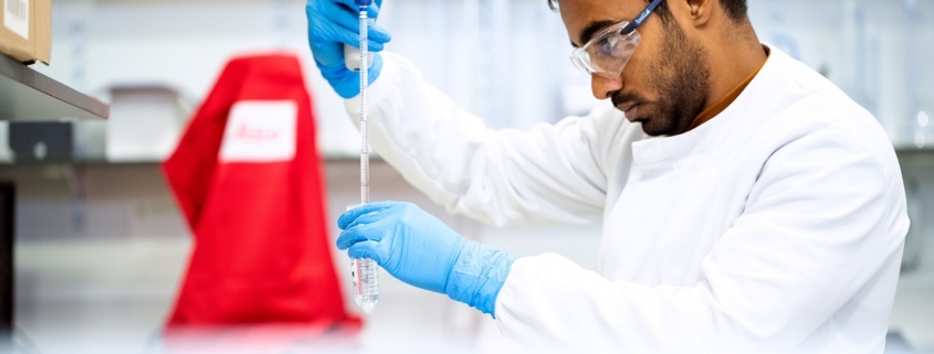 Científico purificando agua en laboratorio con bata blanca