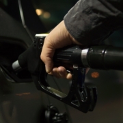 Persona echando bencina a auto en estación de servicio